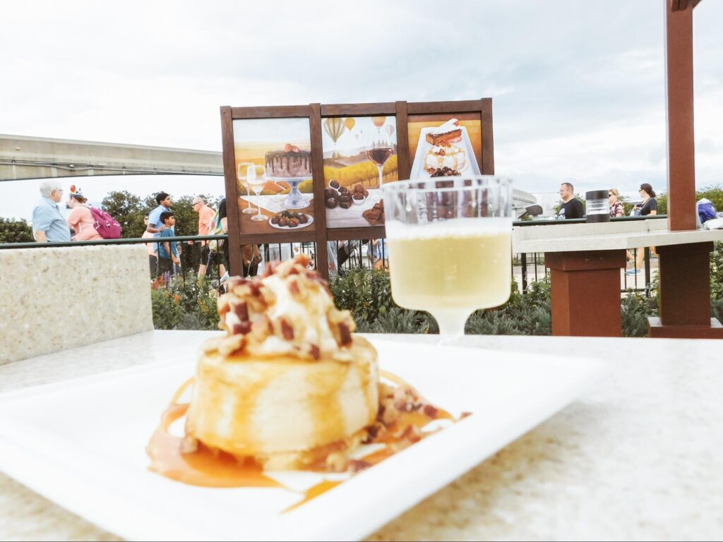 A flan or cheesecake topped with caramel, whipped cream, and almond or pecan pieces.