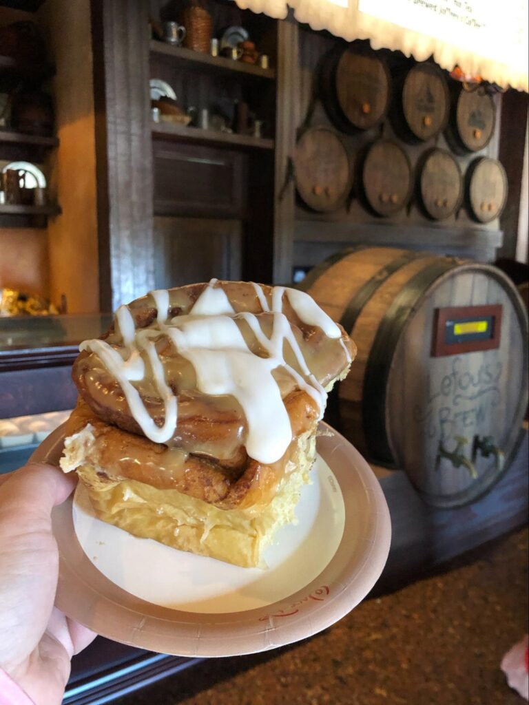 A cinnamon role topped with caramel and icing.