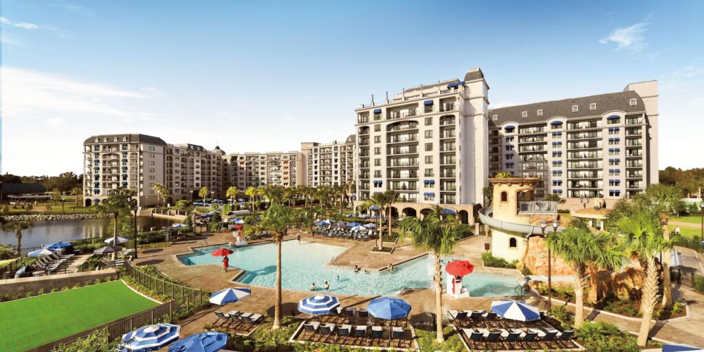 The front of Disney's Riviera Resort, a large white building with a pool in front of it.